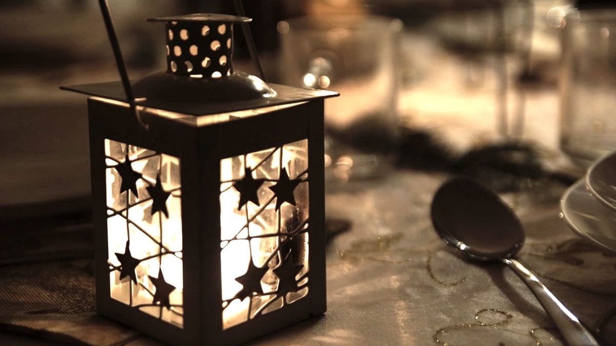 Lanterne allumée sur une table dans une pièce obscure